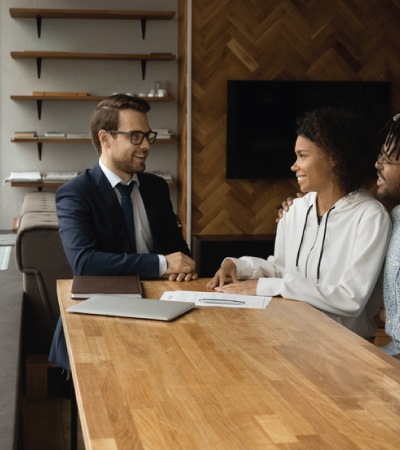 Happy couple sit by desk listen to pleasant male consultant