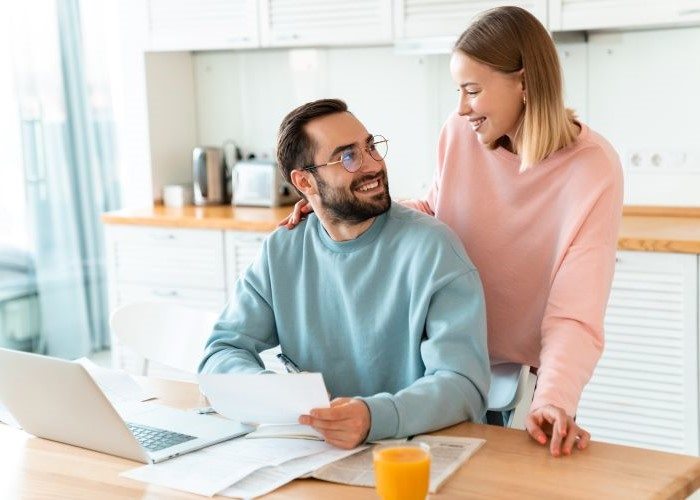 Young couple smiling at each other while going through paperwork