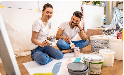 Two people with paintbrushes choosing a color for their DIY project